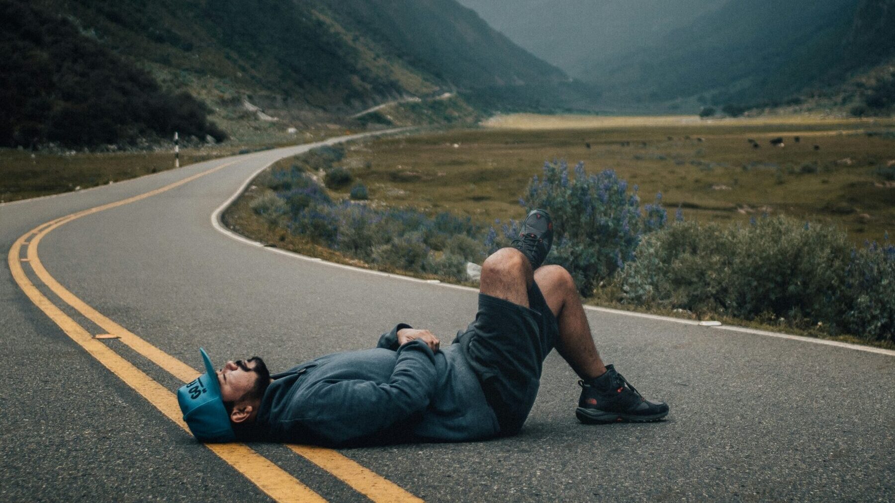 道で横になる男性