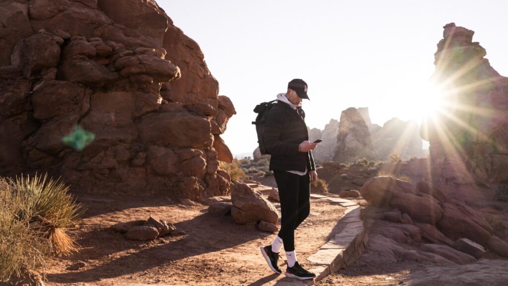 夕日を背景にスマホを触る男性