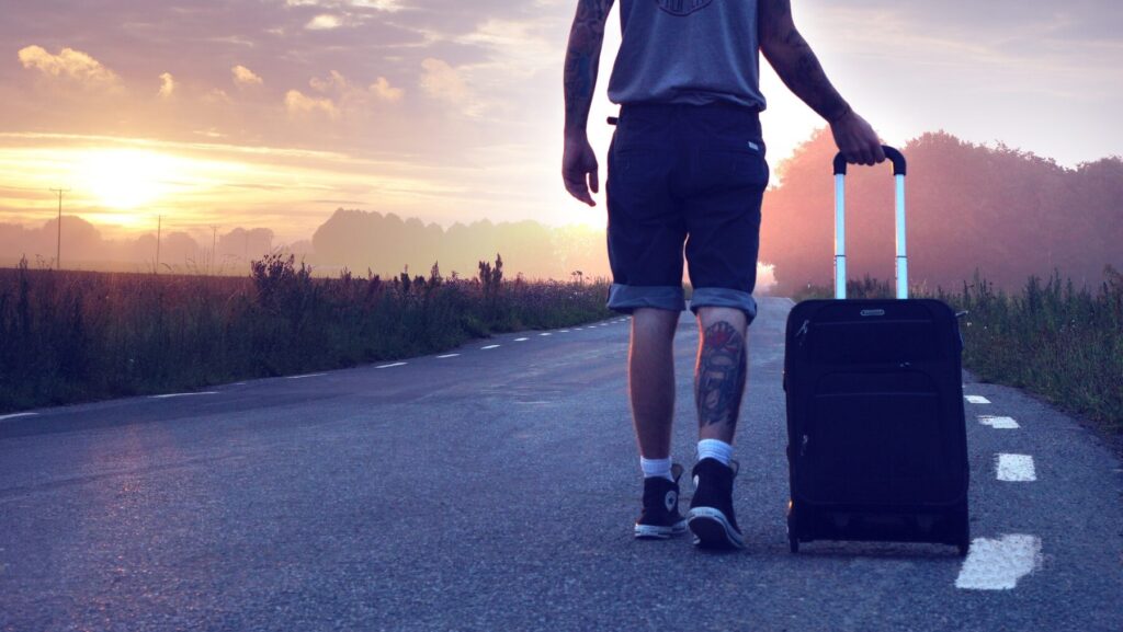 スーツケースを引いて歩く男性