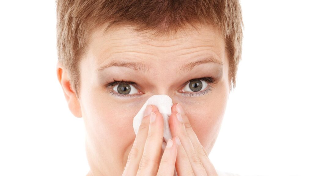 鼻を抑える女性