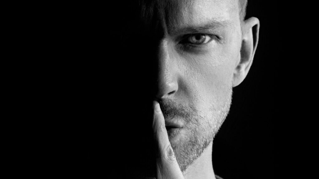 口に指を当てる男性