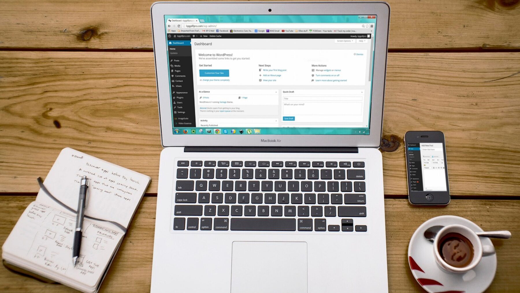 机の上のパソコンとコーヒーとメモ帳