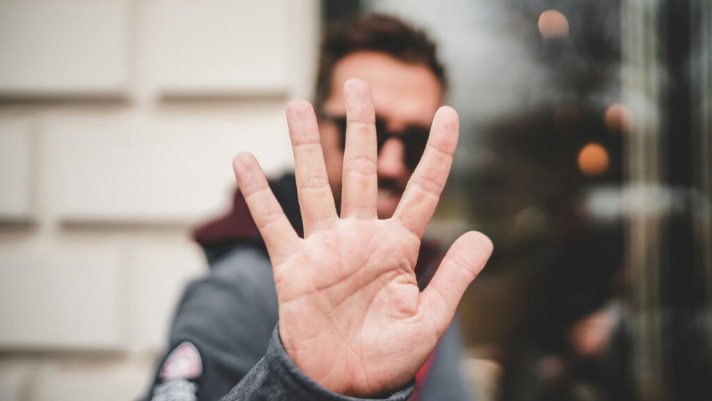 手をかざしストップの合図をする男性