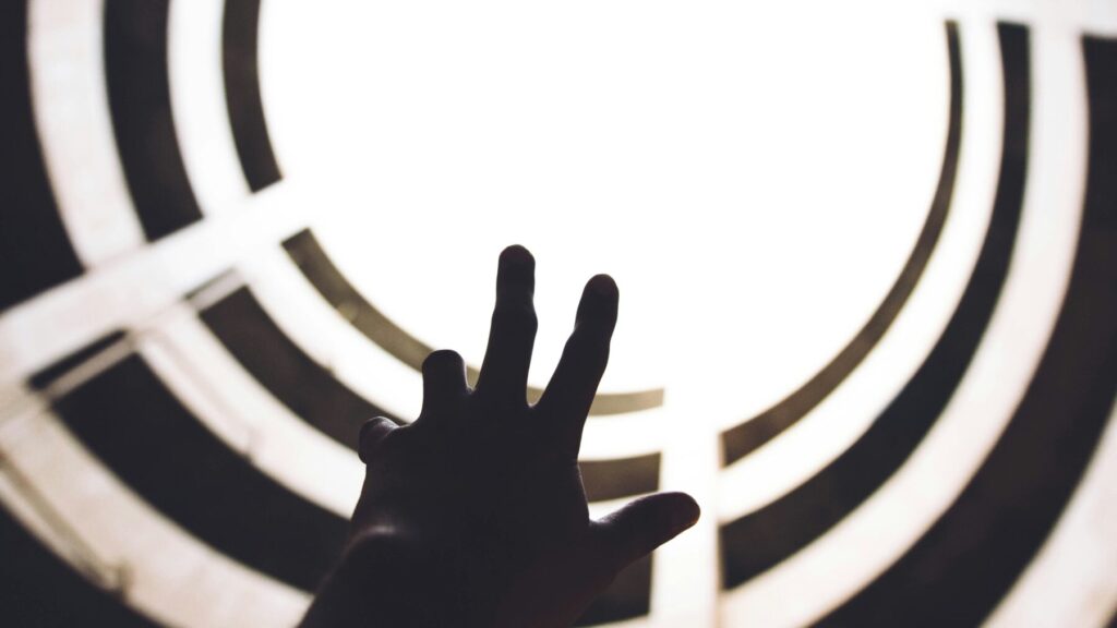 光に向かってもがく手