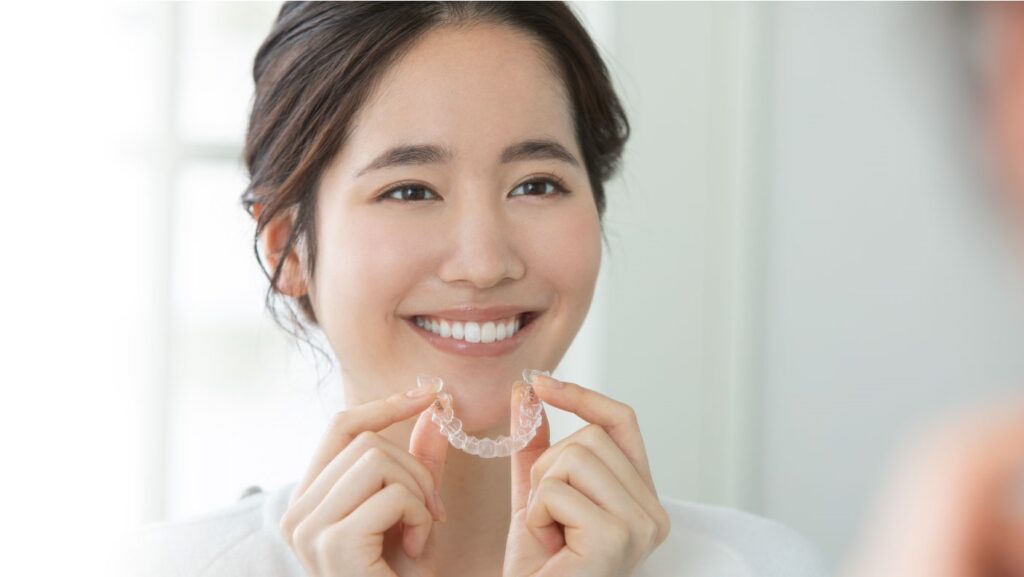 笑顔でマウスピースを持つ女性